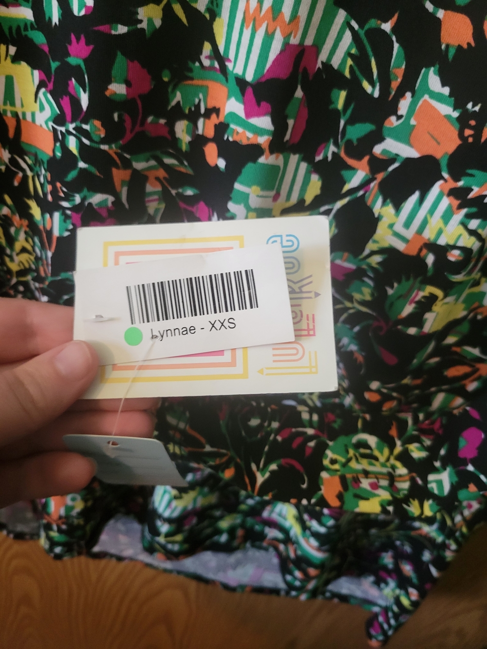 LuLaRoe Women's Top in Black with Green, Orange, Pink and White Print